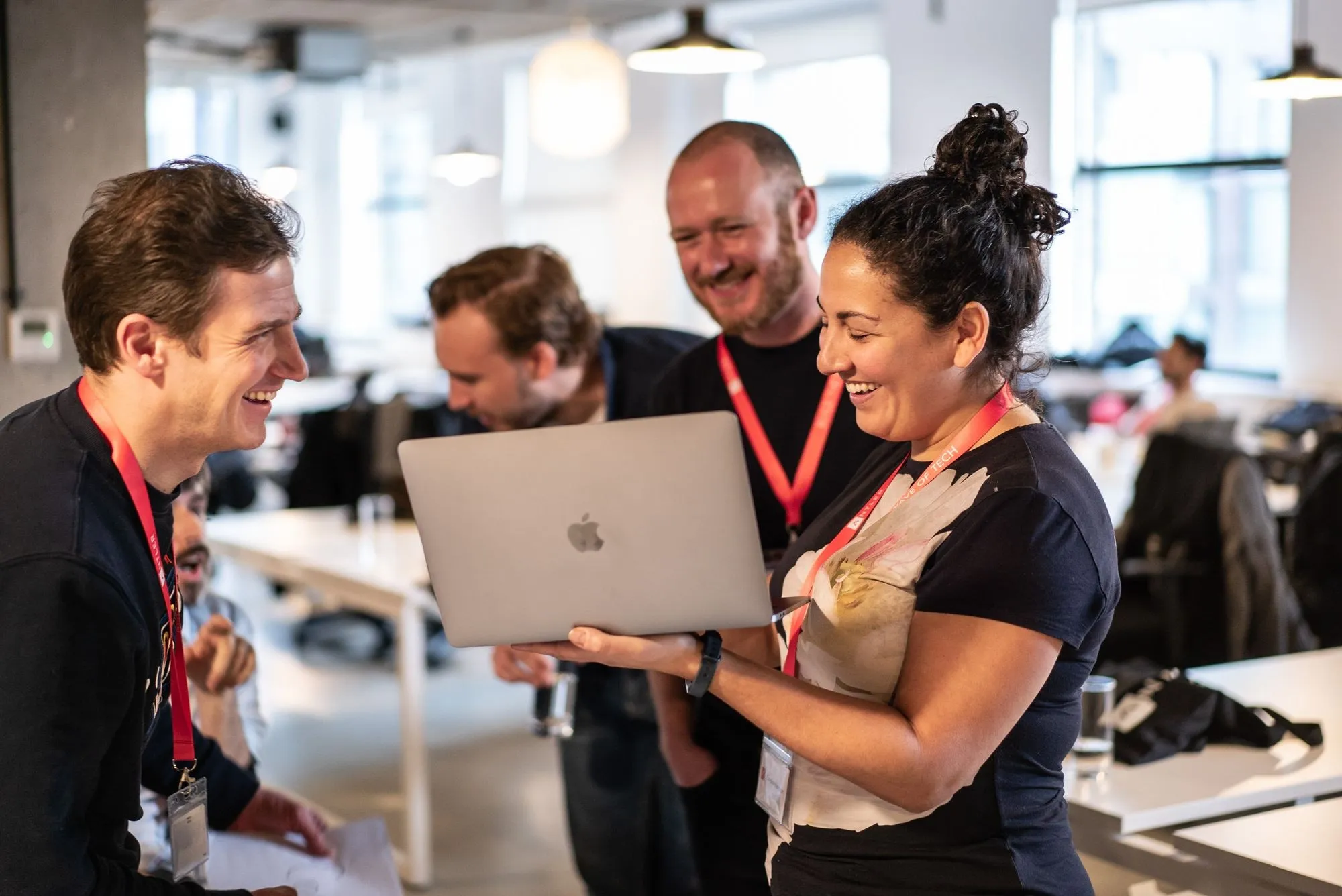 Founders smiling over a laptop in an open-plan office