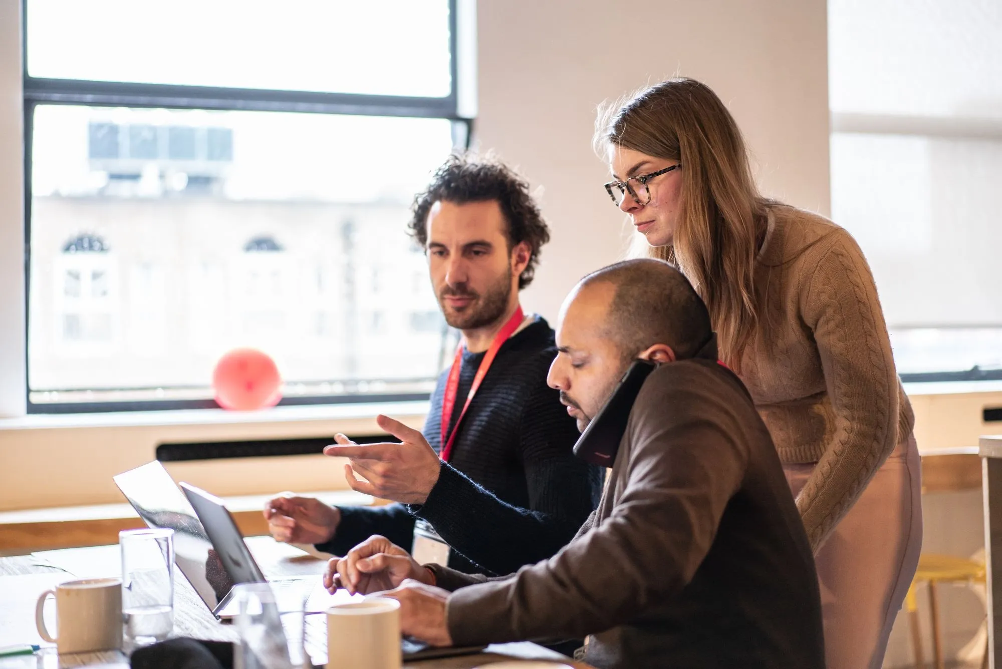 Three founders working through something together on a laptop