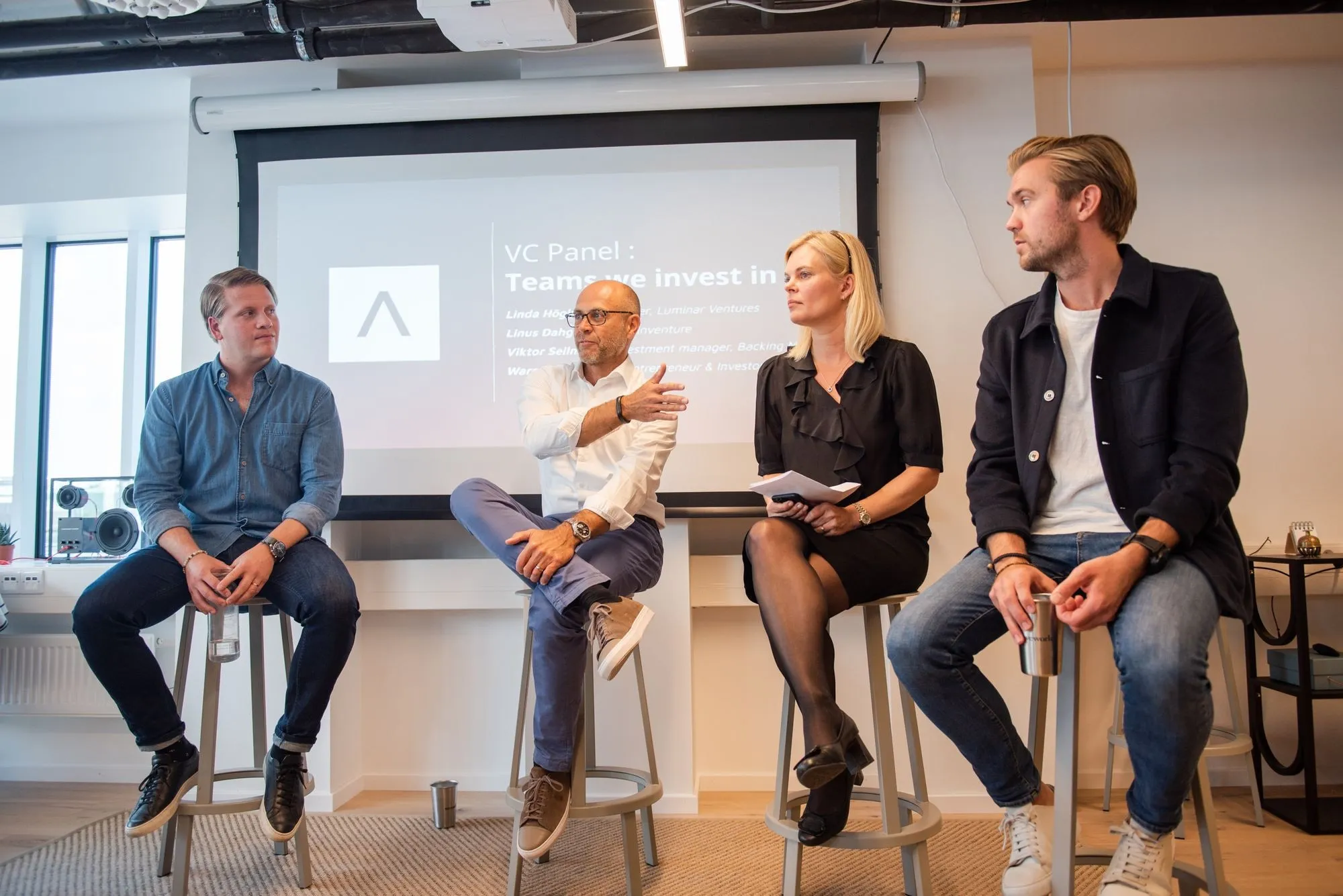 A panel of investors on stage talking about how they back teams